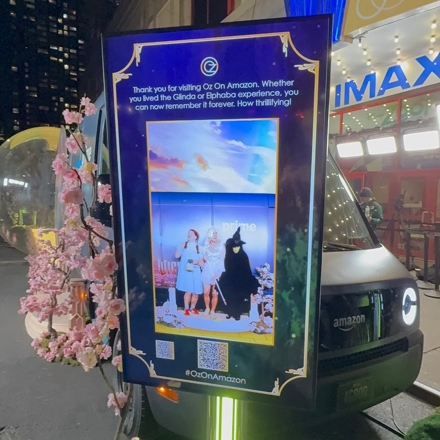 Oz on Amazon: a fan’s Wicked Cam moment on the screen beside the Wicked Prime Van, with a QR code to take it home